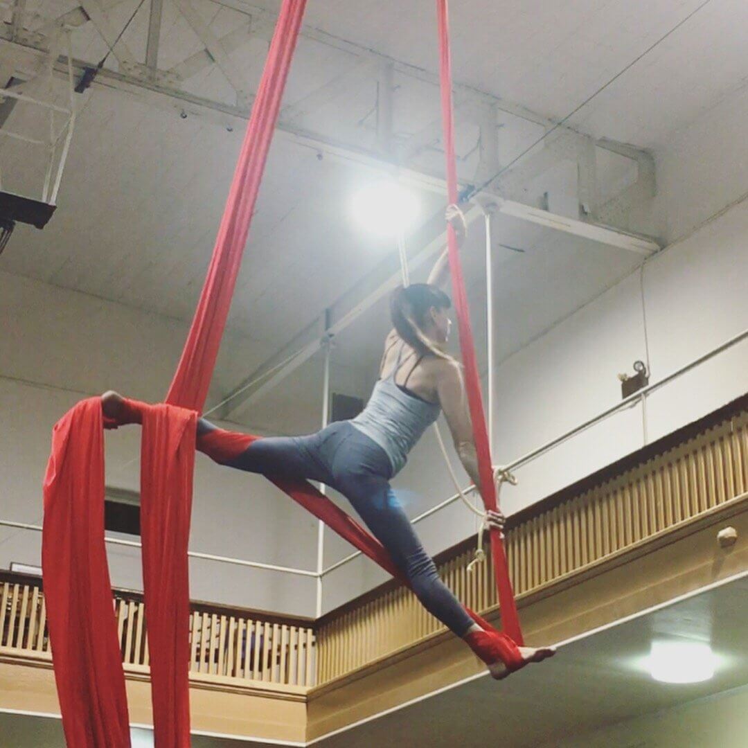 Maya Kumits performing on red aerial silks